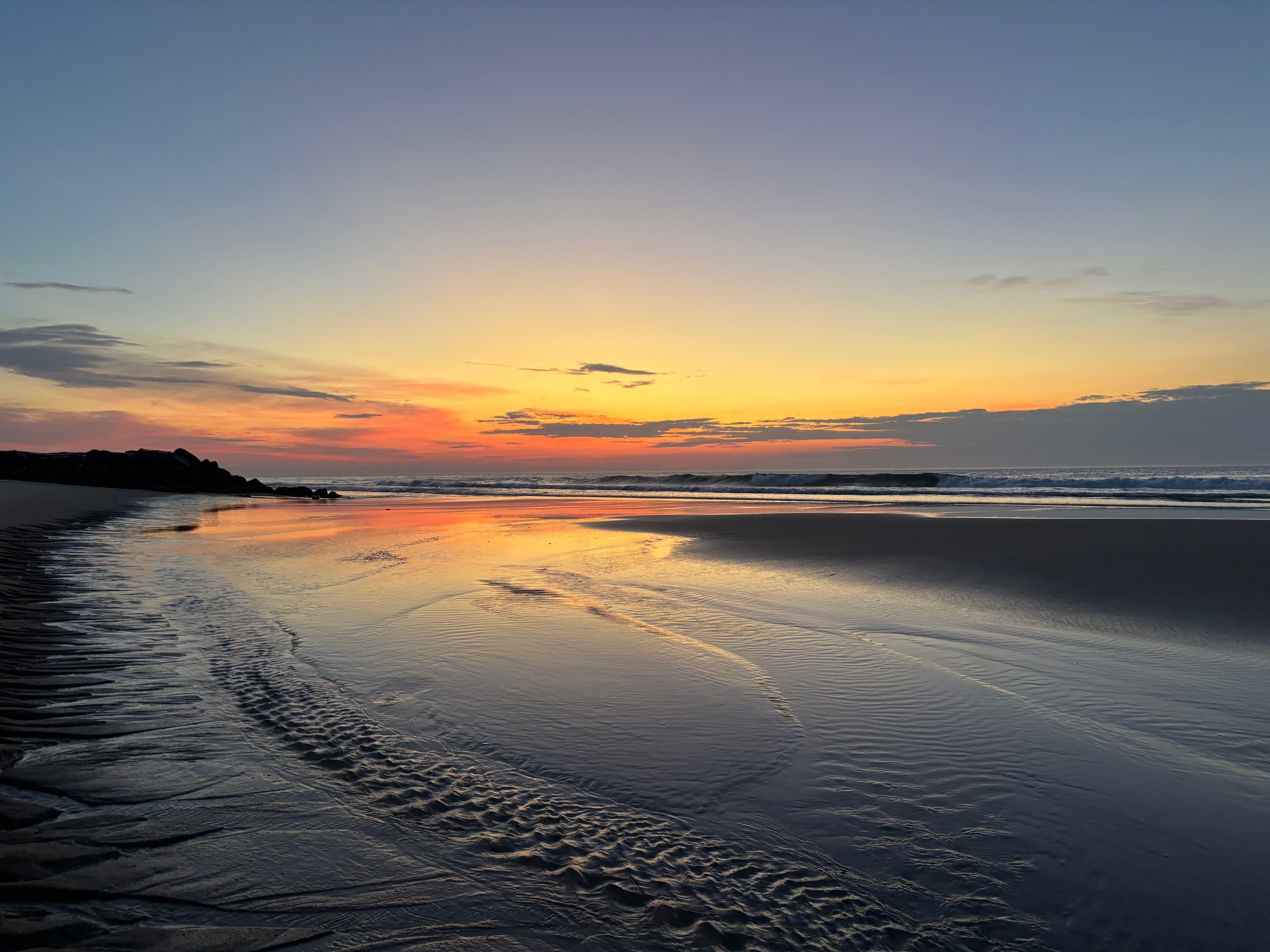 Sunset reflecting across a quiet beach